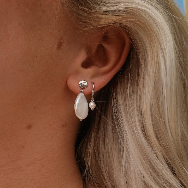 "Summersweet Earrings" features elegant baroque pearl earrings with a silver accent, highlighting a chic and natural style.