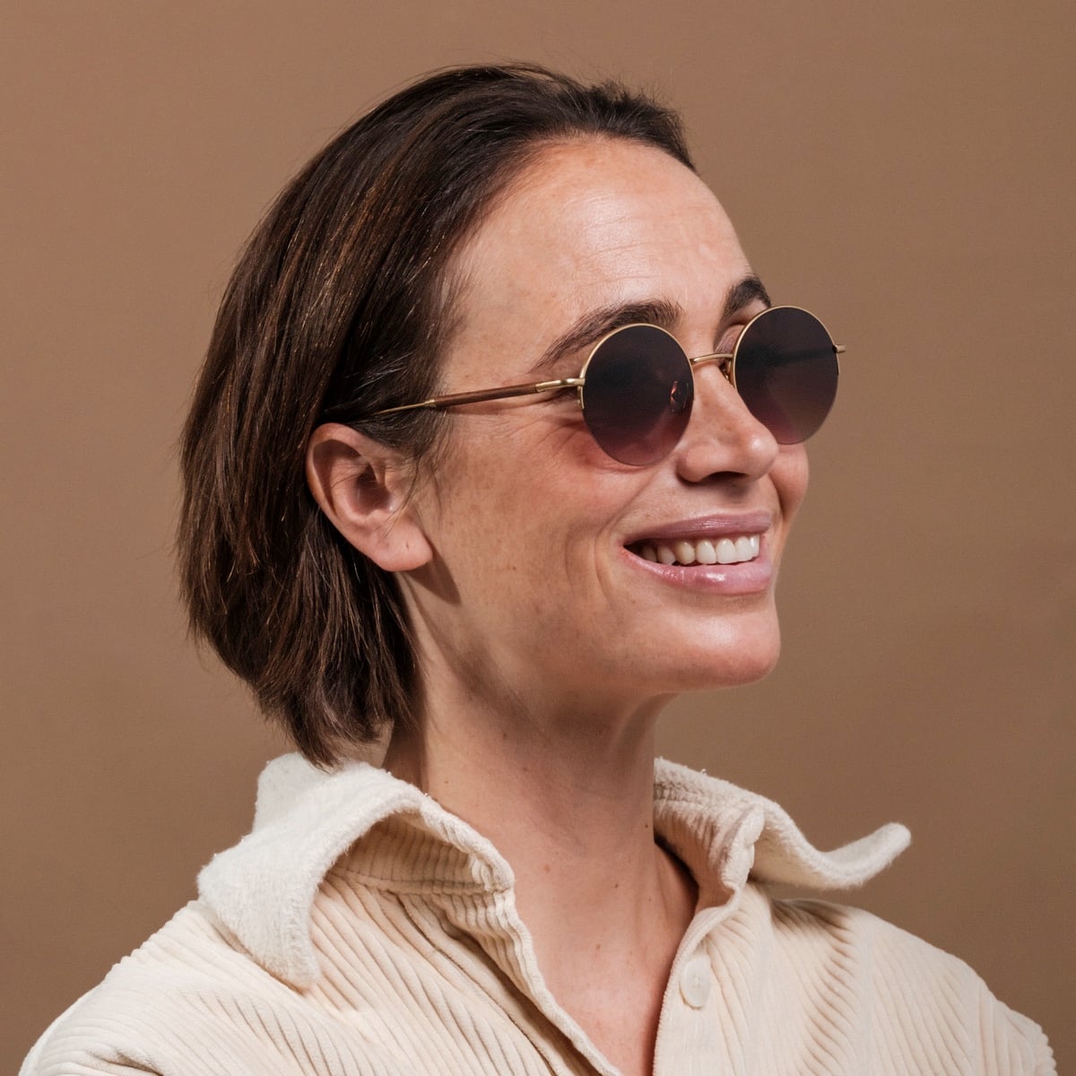 "The Adventurous" sunglasses, featuring a stylish round design with walnut and gold accents.