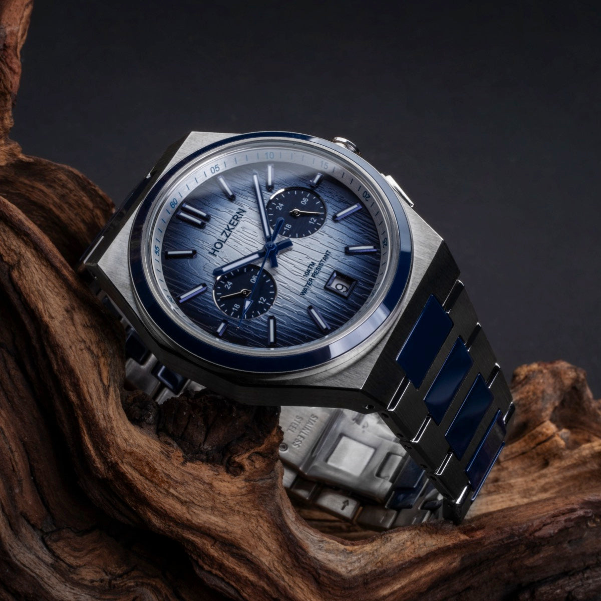 Montre "Oceanswell" avec une structure en céramique et argent, avec un design élégant et moderne sur fond en bois.
