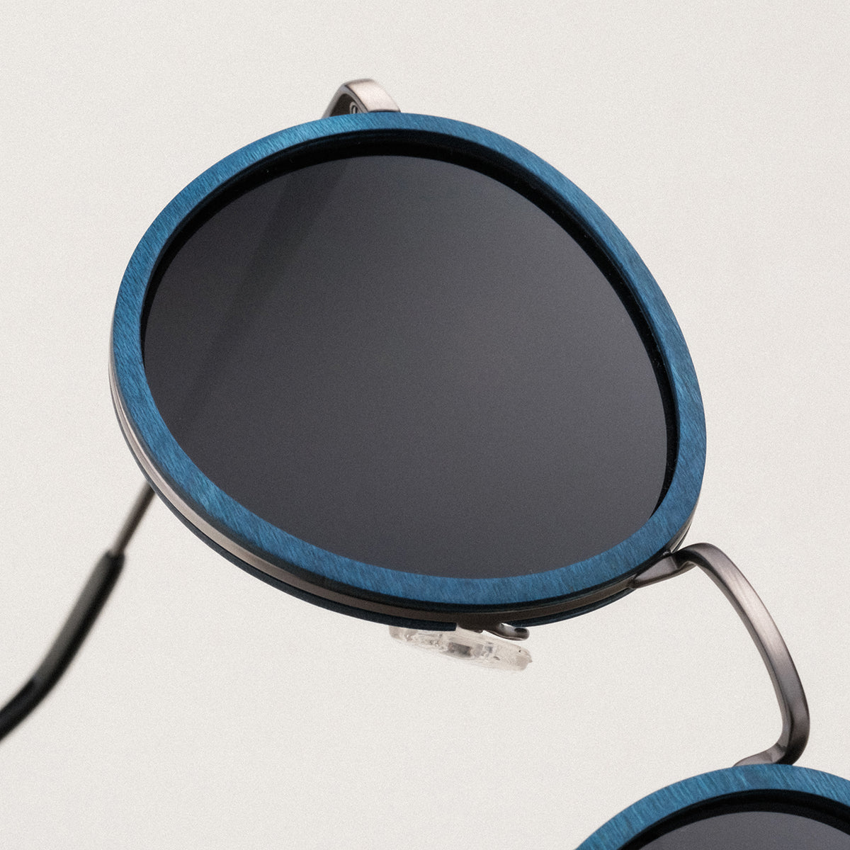 "The Loving" sunglasses, featuring a sleek maple and dark grey design with round lenses.