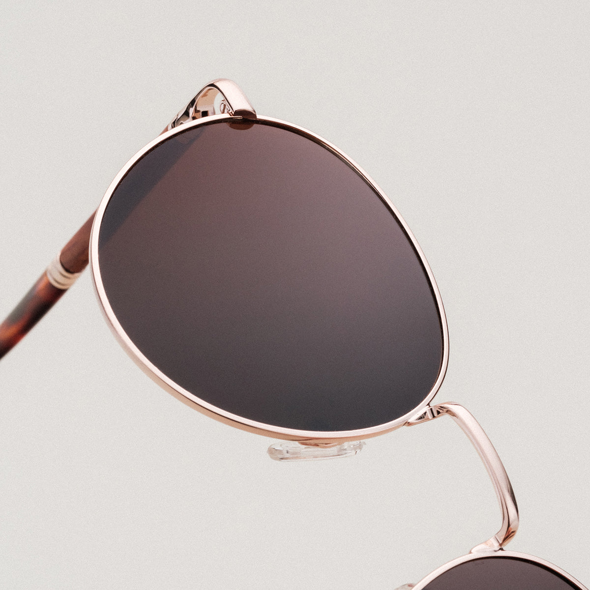 "The Achiever" sunglasses with a sleek Padauk frame and matte gold finish, showcasing an elegant and modern design.