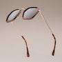 "The Sincere" sunglasses featuring a walnut frame with a matte gold finish, showcasing an elegant and modern design.