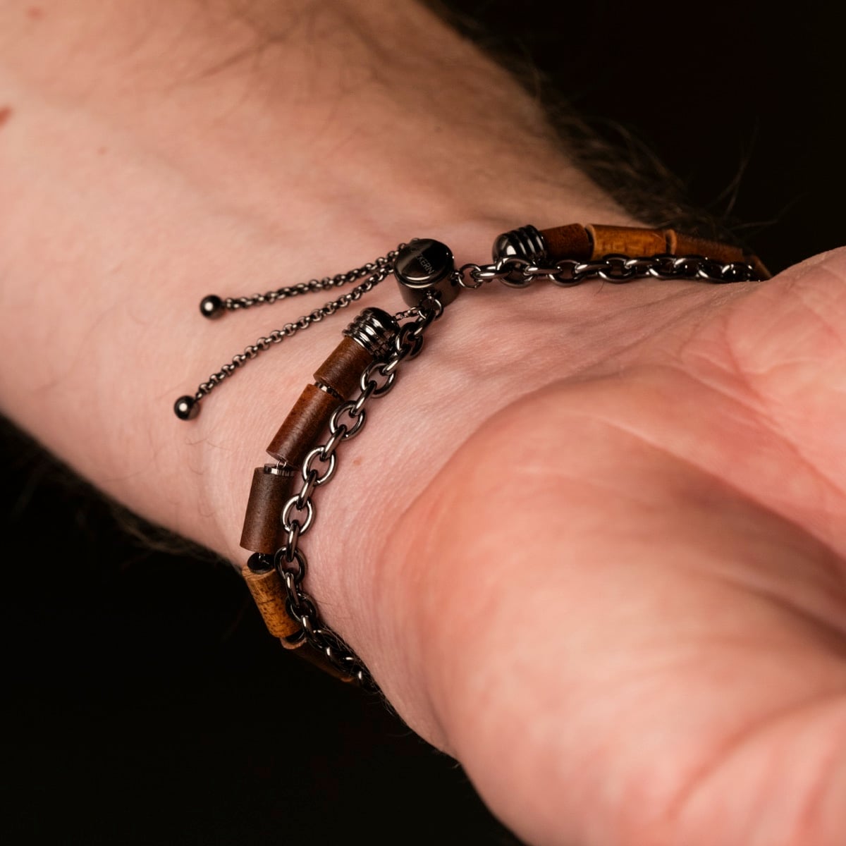 Bracelet "Supersonic" avec un mélange unique de bois de koa et d'éléments en métal gris sur un poignet.
