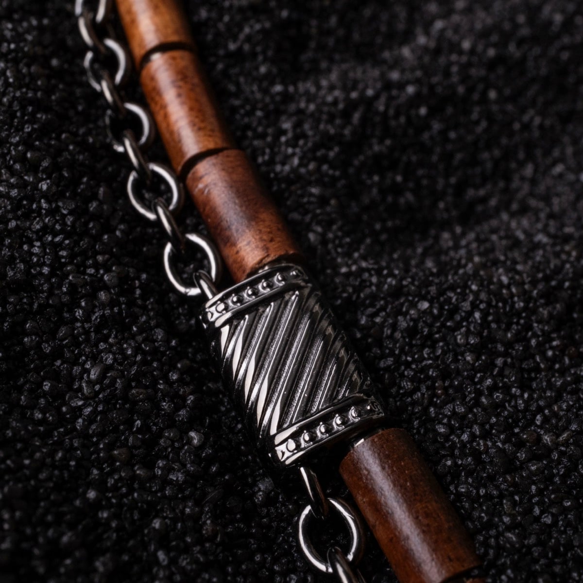 Collier "Supersonic" combine bois de koa et métal gris, avec un design élégant et texturé.