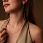 "Summersweet Earrings II": Elegant pearl and rose gold earrings with a delicate, elongated design.