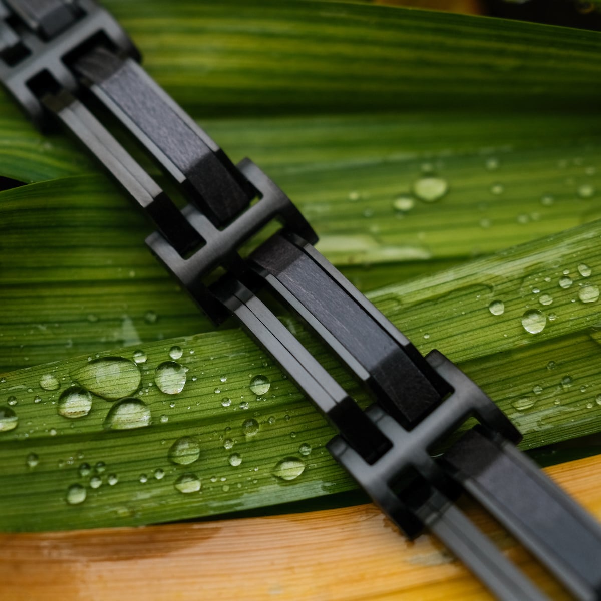 Le bracelet "Staccato" est orné d'un motif érable élégant et noir sur fond naturel de feuille.