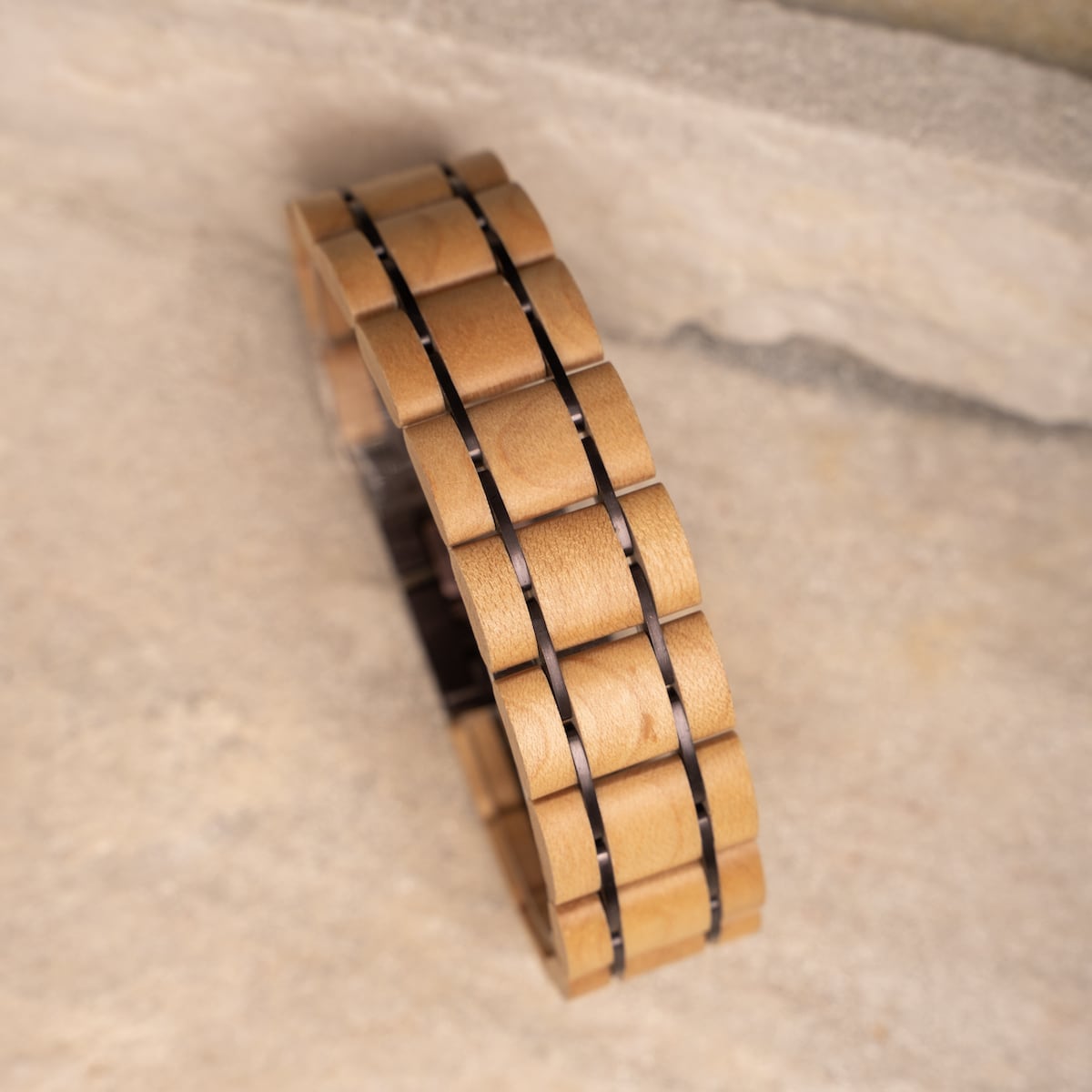 Pulsera "Grandezza", con arce y materiales púrpuras oscuros en un diseño elegante y moderno.