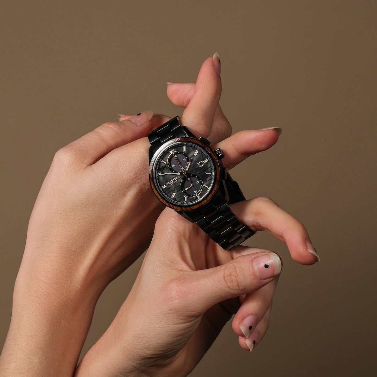 "Endowment" Watch, med en Marble och Zebrawood design, hjälte i händer mot en neutral bakgrund.
