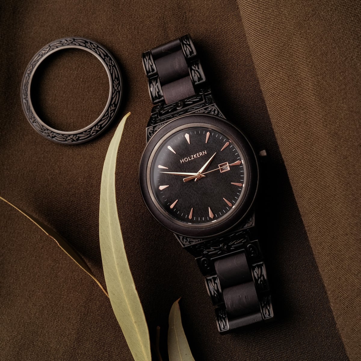 Reloj "Khalili" con esfera negra, diseño intrincado y acentos de arce para un estilo elegante.