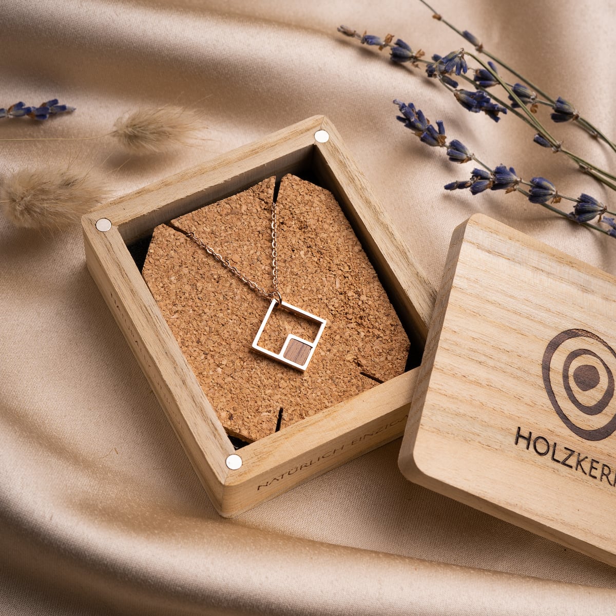 "Geometric Necklace" features a geometric design in walnut and rose gold, elegantly presented in a wooden box.
