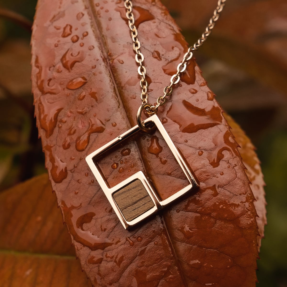 "Geometric Necklace" necklace featuring a geometric walnut and rose gold design on a delicate chain.
