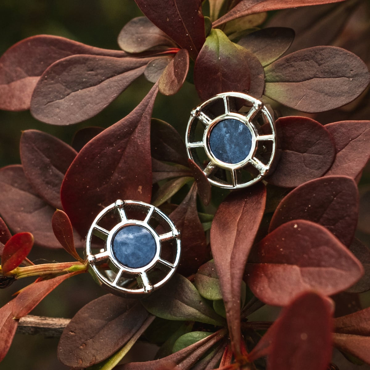 "Amulet Earrings" features elegant marble and silver earrings with a circular, geometric design.
