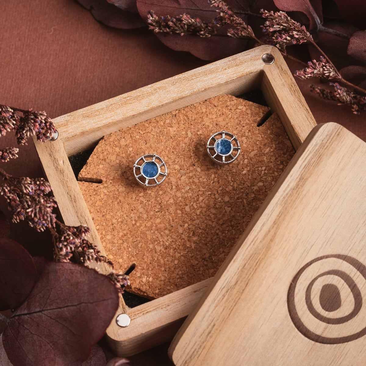 "Amulet Earrings" earrings, featuring a marble and silver design in an elegant wooden box.
